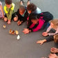 Kids sitting in a circle gently holding newly hatched chicks